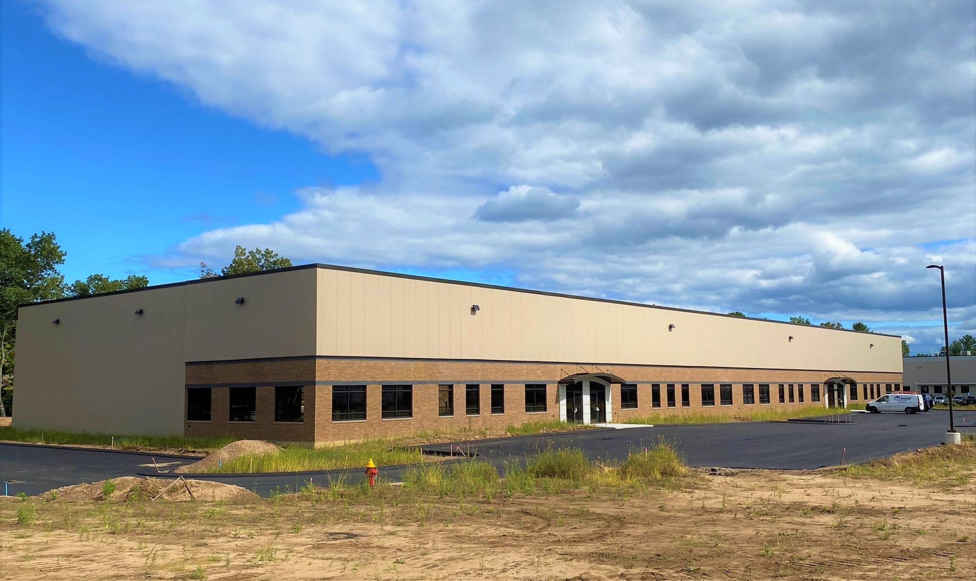 A large building with a lot of windows is sitting in the middle of a field.