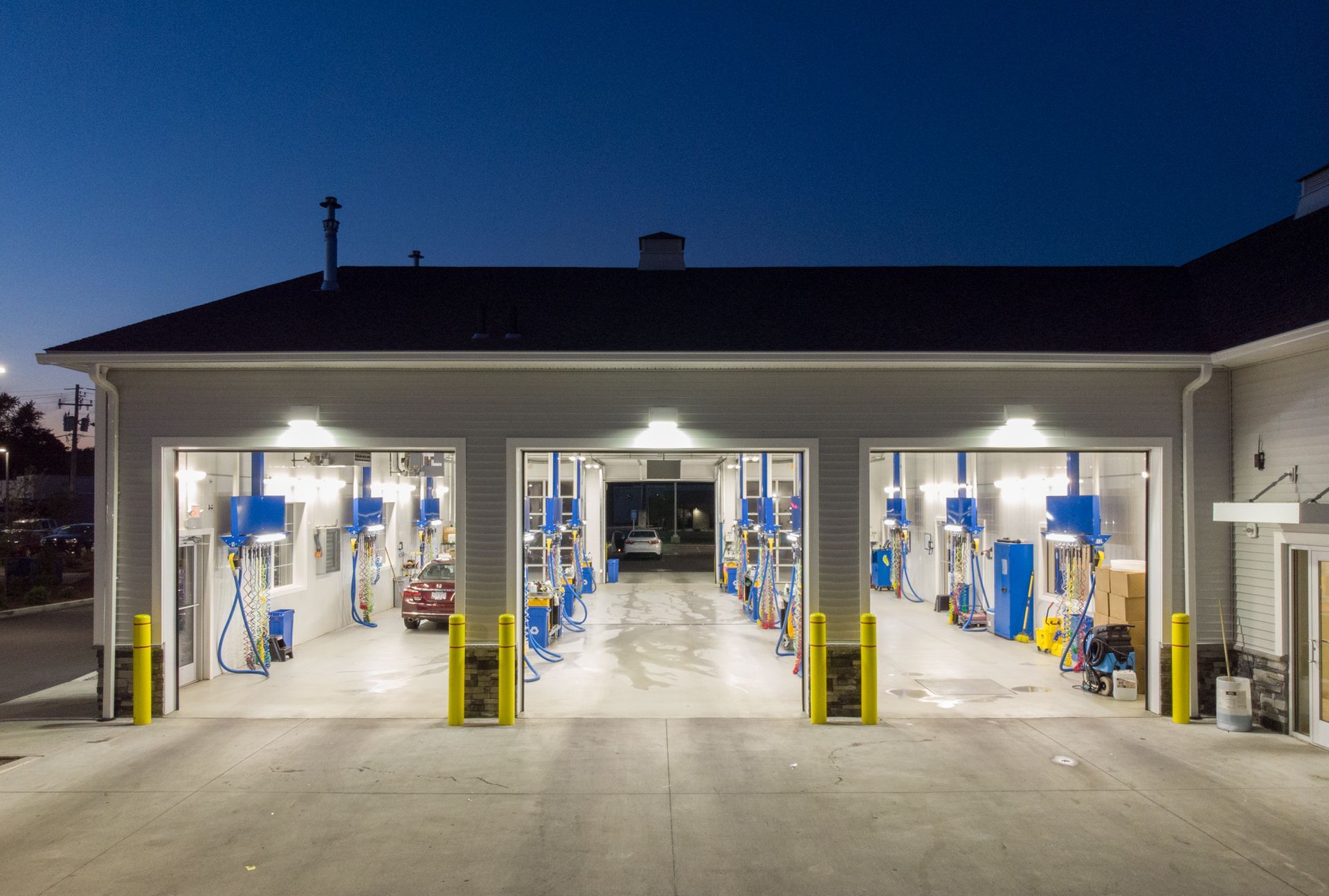 A large garage with a lot of doors open at night.