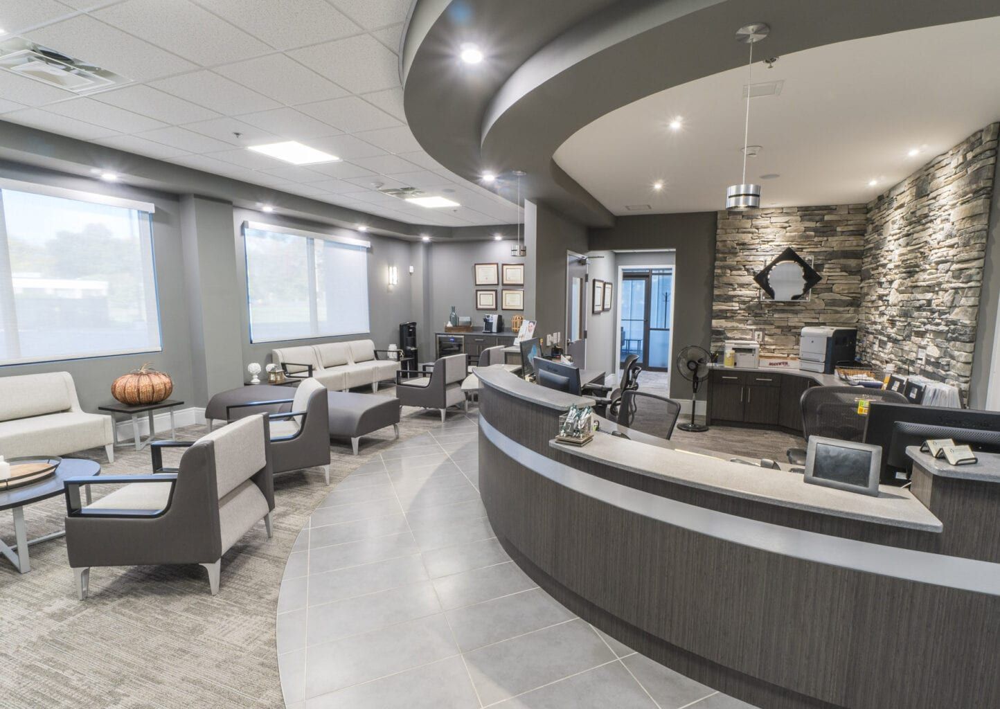 A large room with a reception desk and chairs in it.