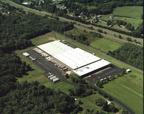 An aerial view of a large white building surrounded by trees