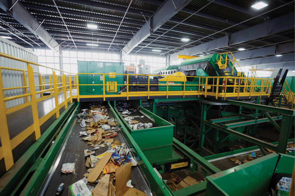 A large green and yellow machine is in a warehouse