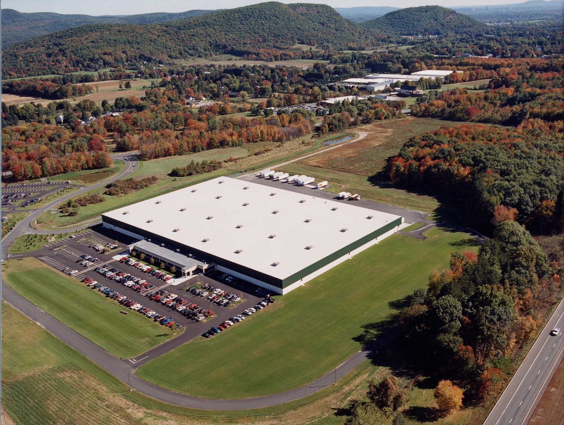 An aerial view of a large white building surrounded by trees