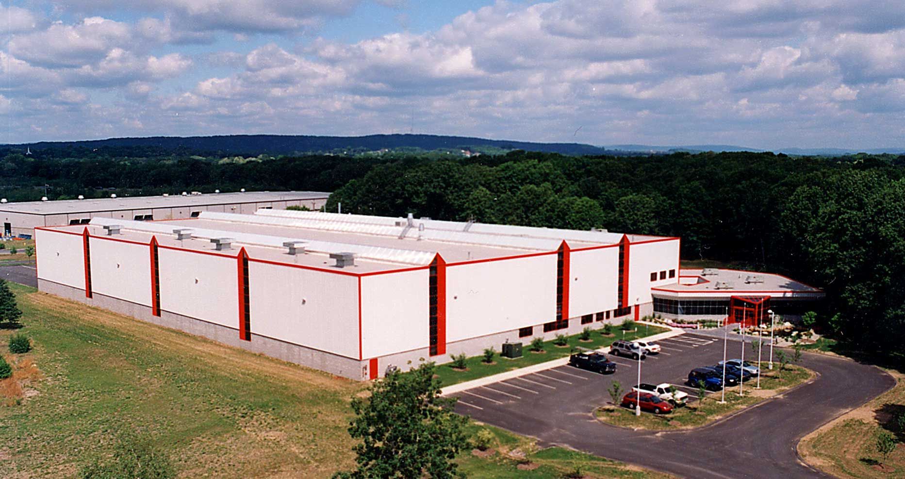 An aerial view of a large white building with red trim