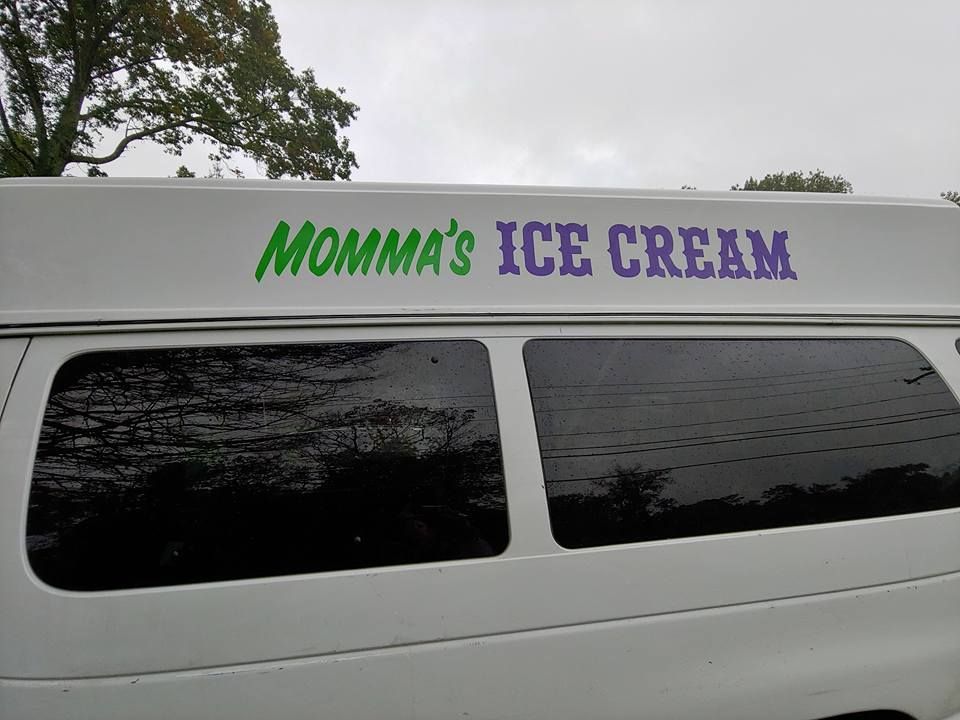 The side of a white van with the green and purple text