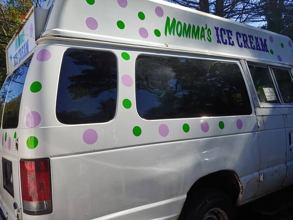 A white van decorated with purple and green polka dots and the text