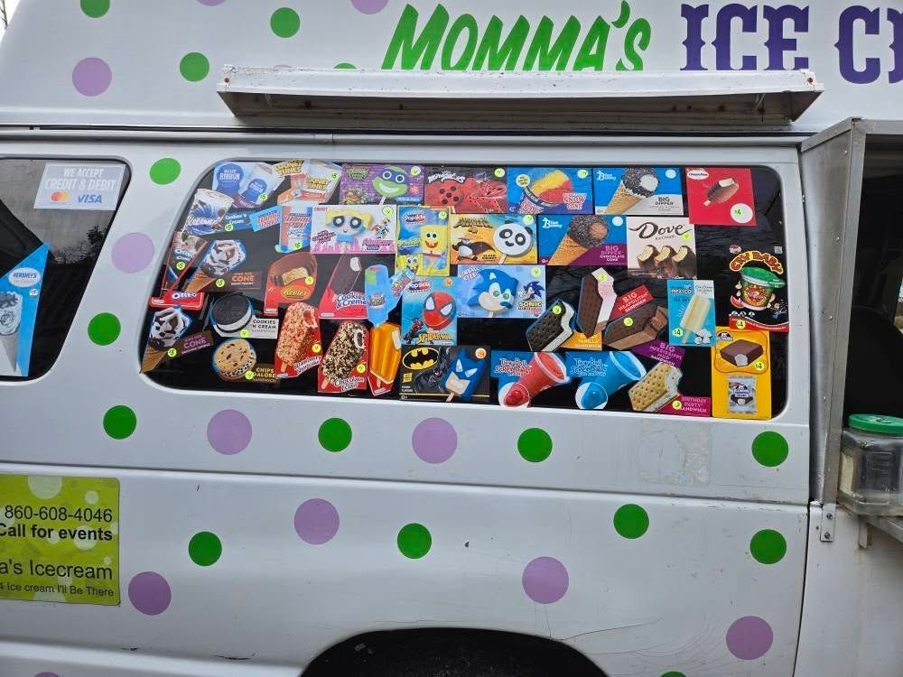 A white ice cream truck with purple and green polka dots displays a menu window filled with various character popsicles.