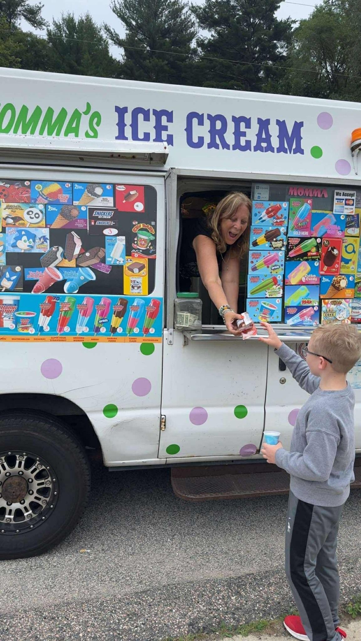 A person serving an ice cream treat from a white
