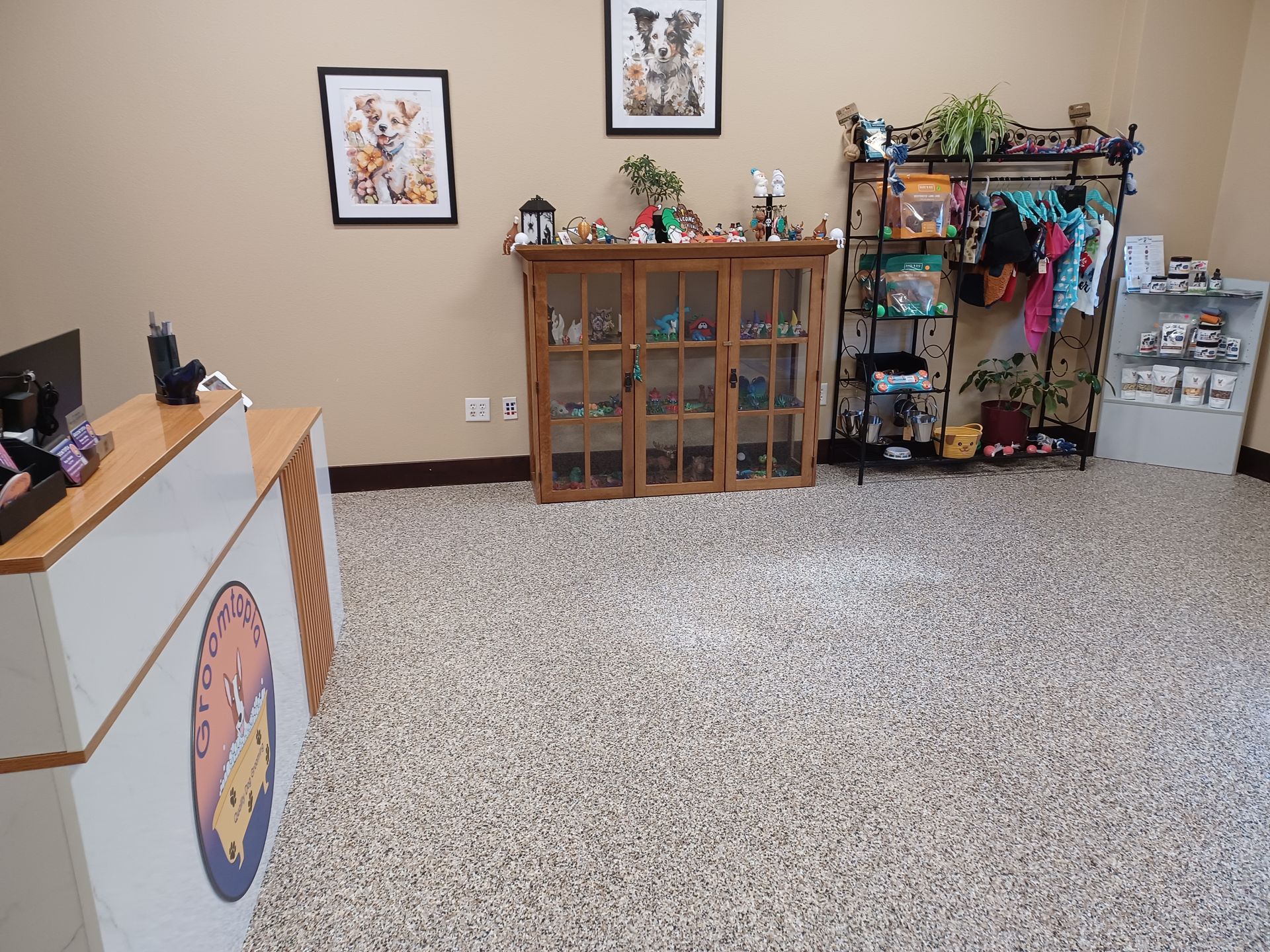 A room with a carpeted floor , a counter , and a shelf with clothes on it.