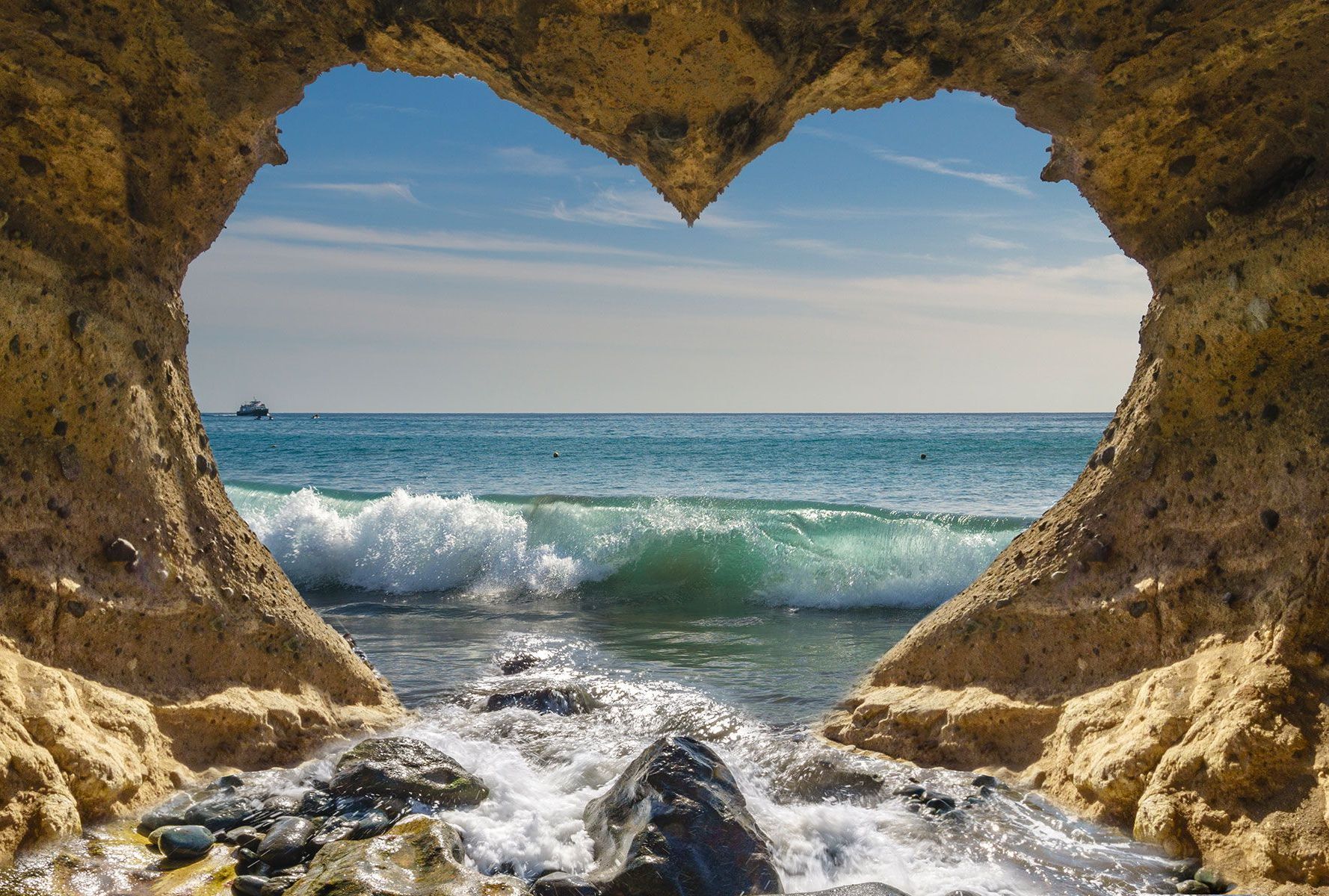 A man is sitting at a desk with his hands behind his head in front of a laptop computer.