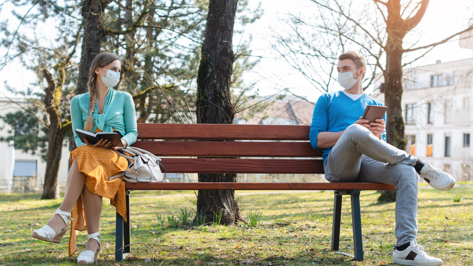 Two Friends Social Distancing and Staying Six Feet Apart While in a Park