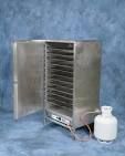 Silver food dehydrator with open door and white container.