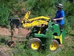 A Man Is Driving A Green And Yellow Tractor In A Field – Caboolture, QLD - R & R Hire Services