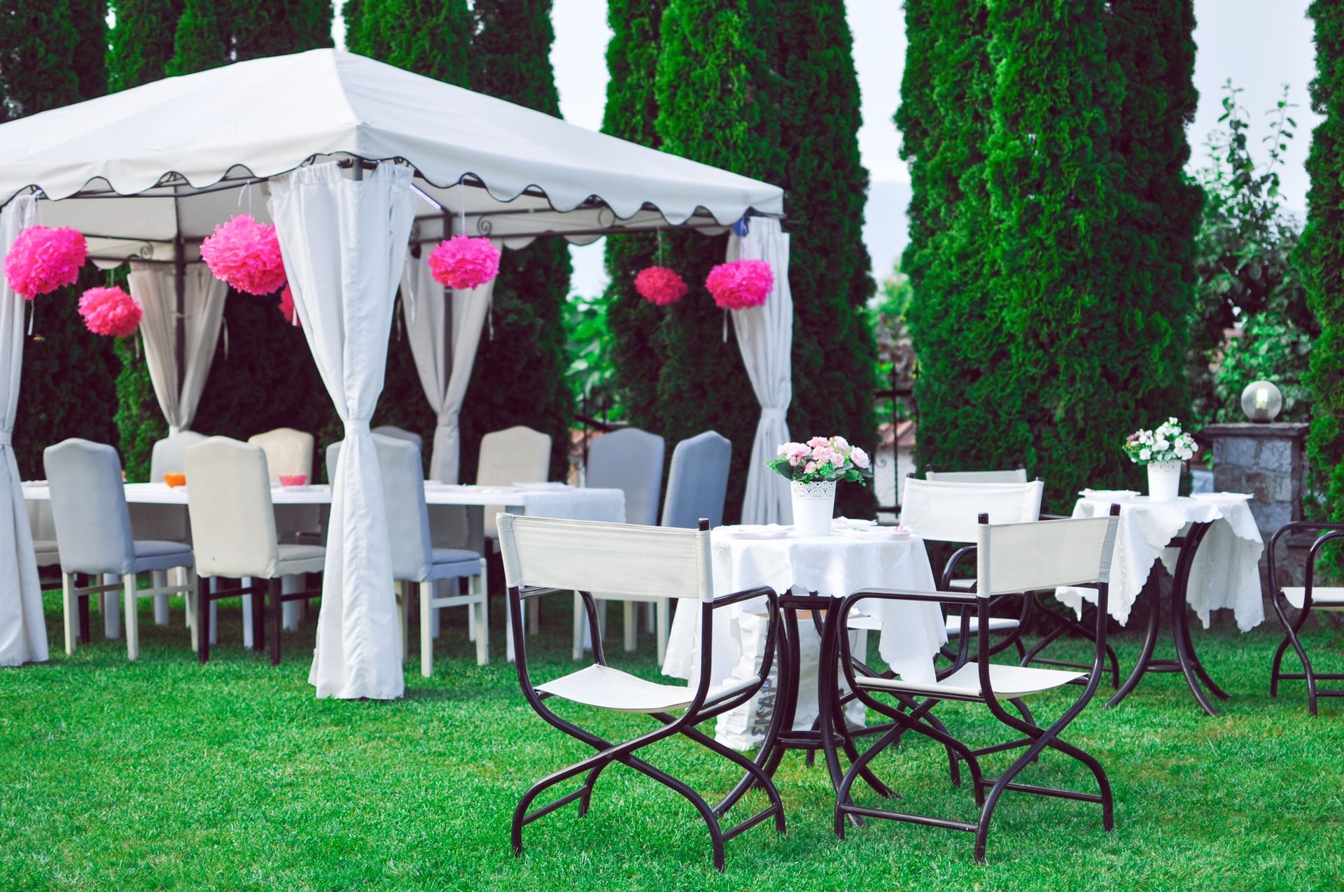 Party tables in garden with plates and glasses.