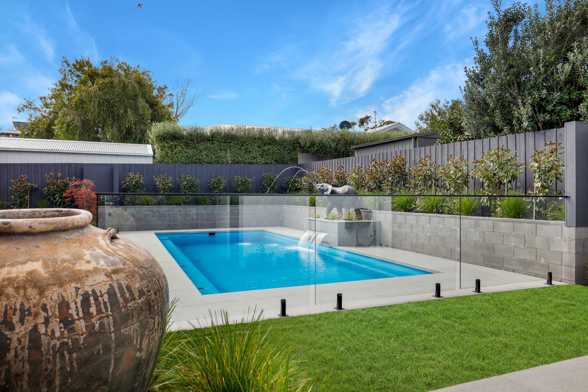 a swimming pool with a glass fence around it