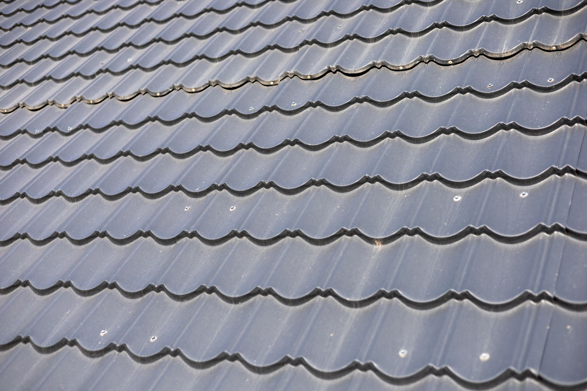 Gray metal roof with curved tile pattern.