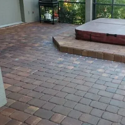 Brick patio with a hot tub on a raised brick platform; outdoor setting.