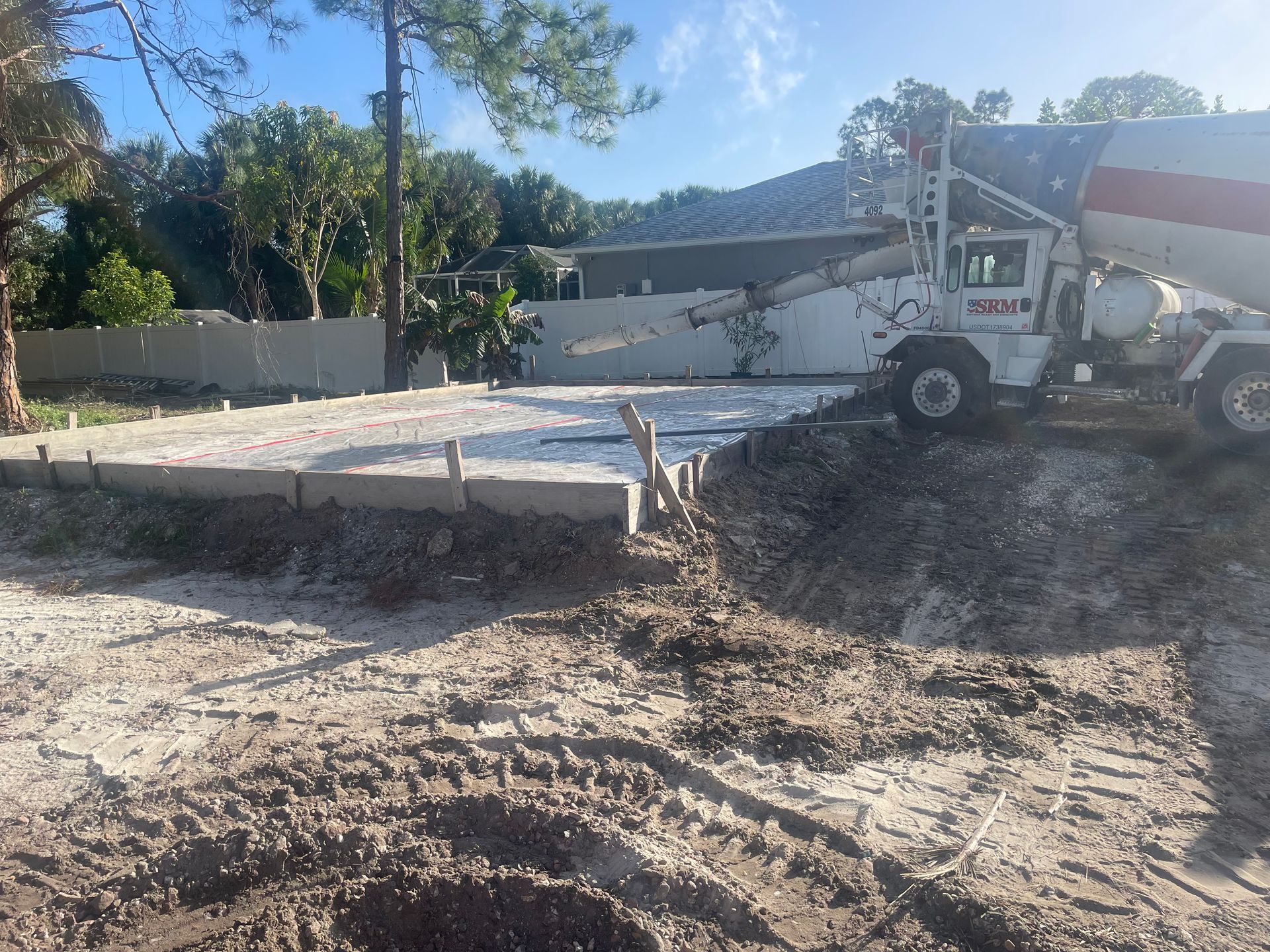A cement truck pouring concrete into a prepared form at a construction site.
