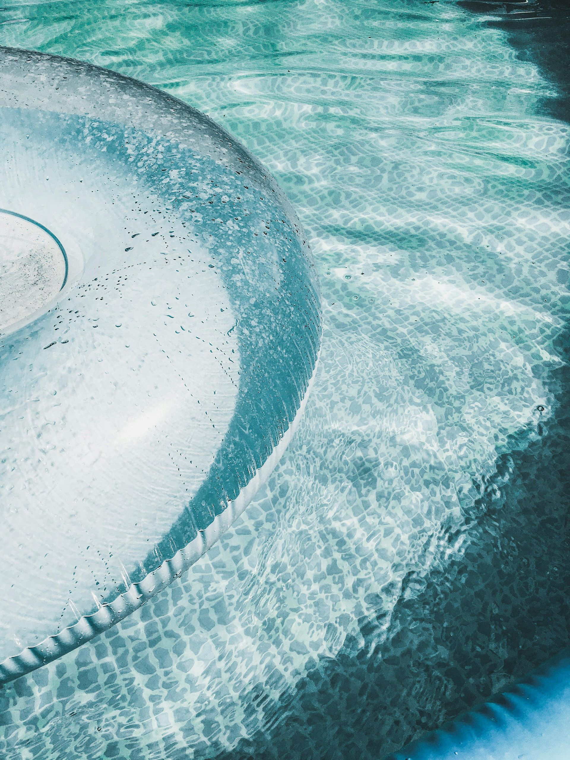 A clear inflatable ring is floating in a swimming pool.