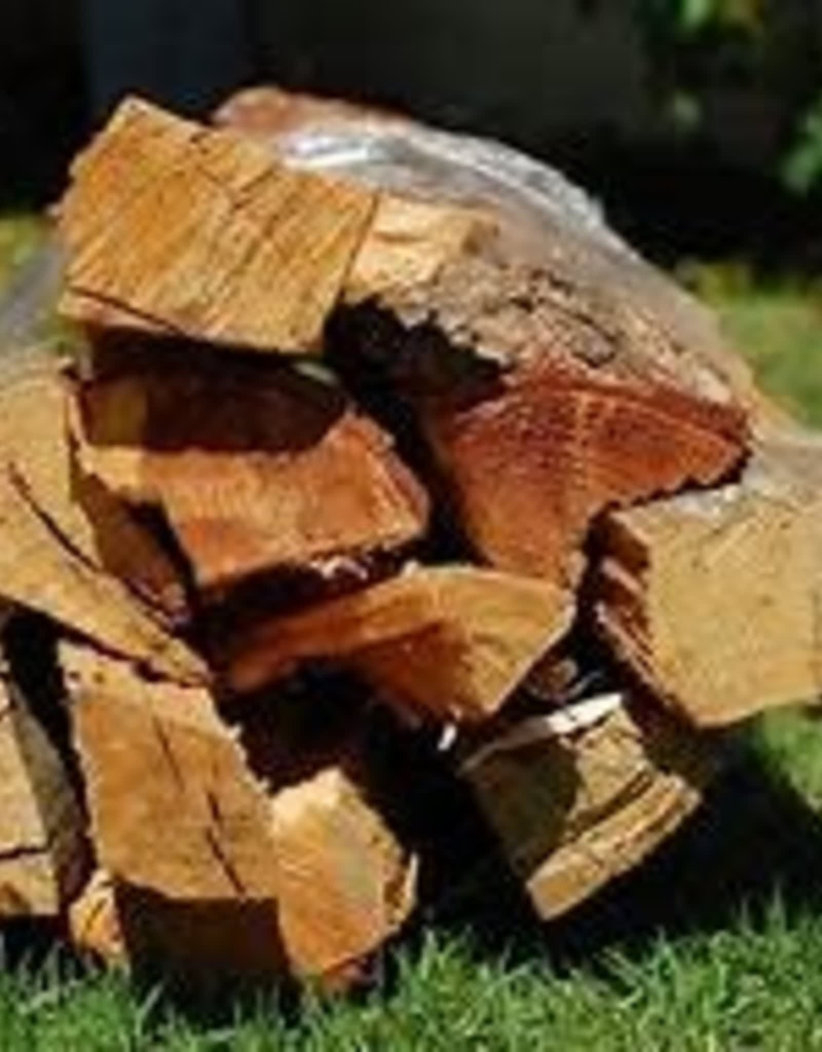 Stack of split firewood logs on grass outdoors