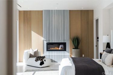 A bedroom with a fireplace and a bed.