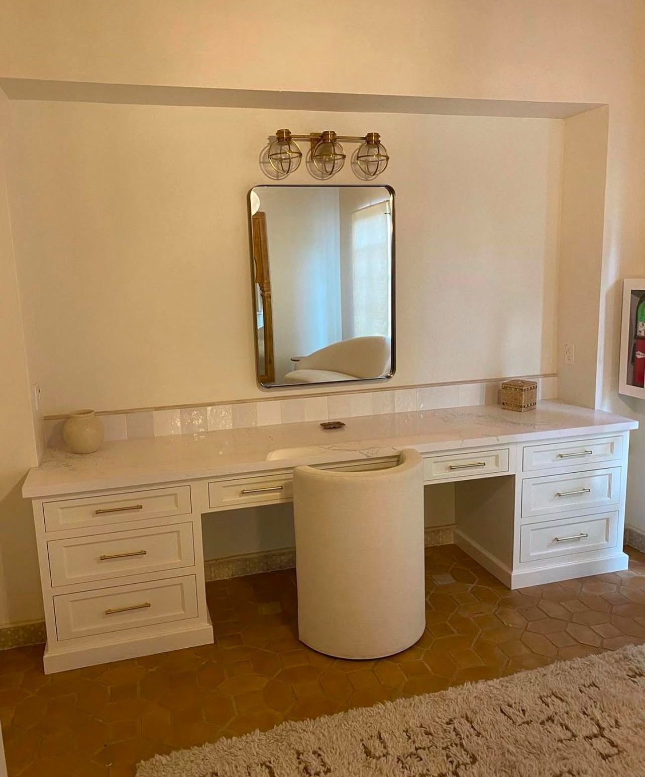 A white vanity with a mirror on top of it in a room.