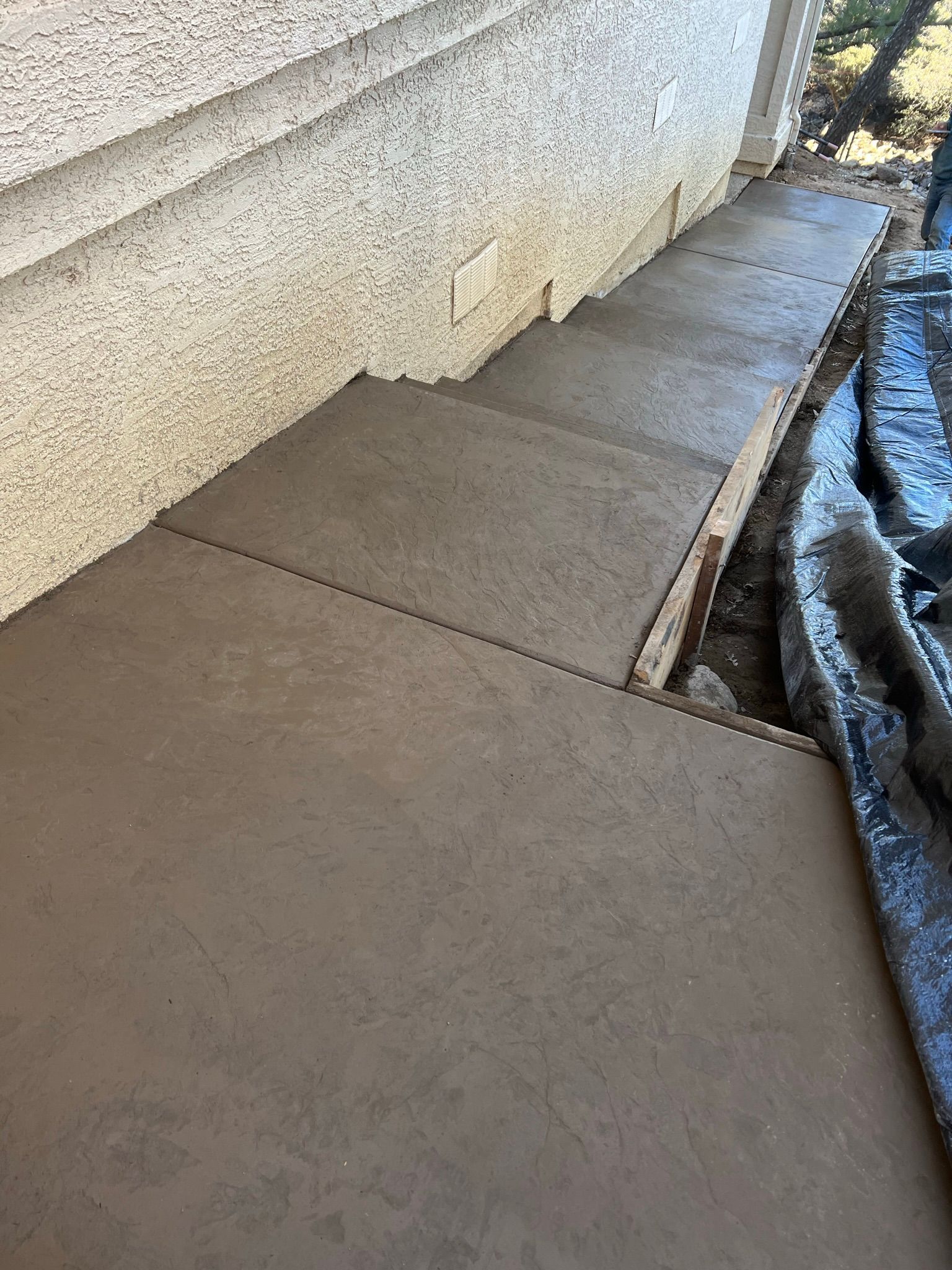 A concrete walkway is being built on the side of a building.