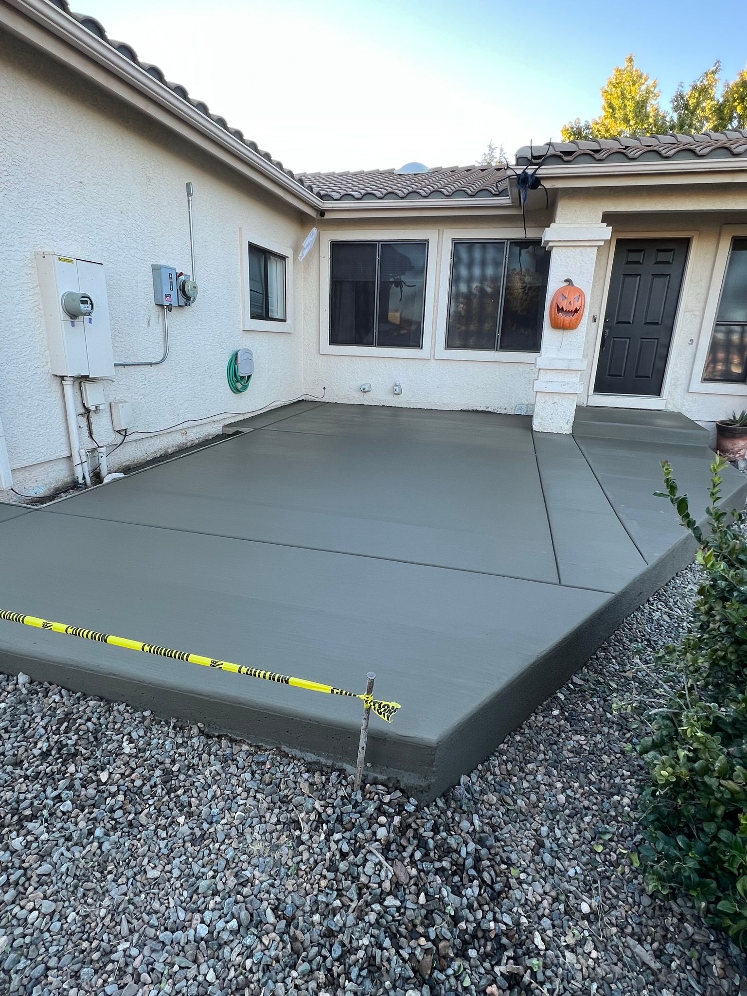 A concrete patio is being built in front of a house.