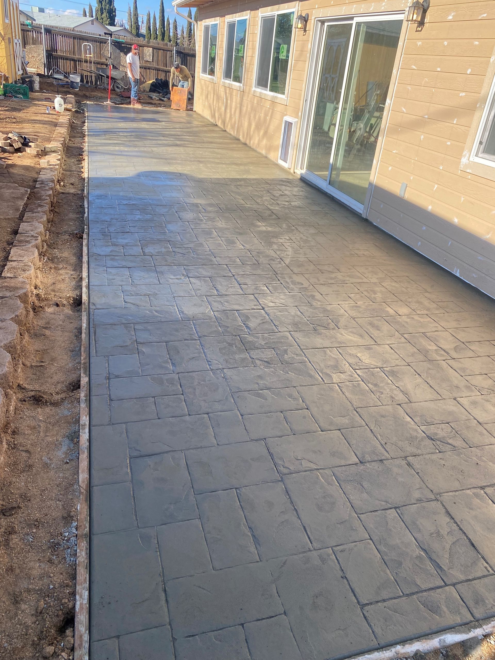 A concrete walkway is being built in front of a house.