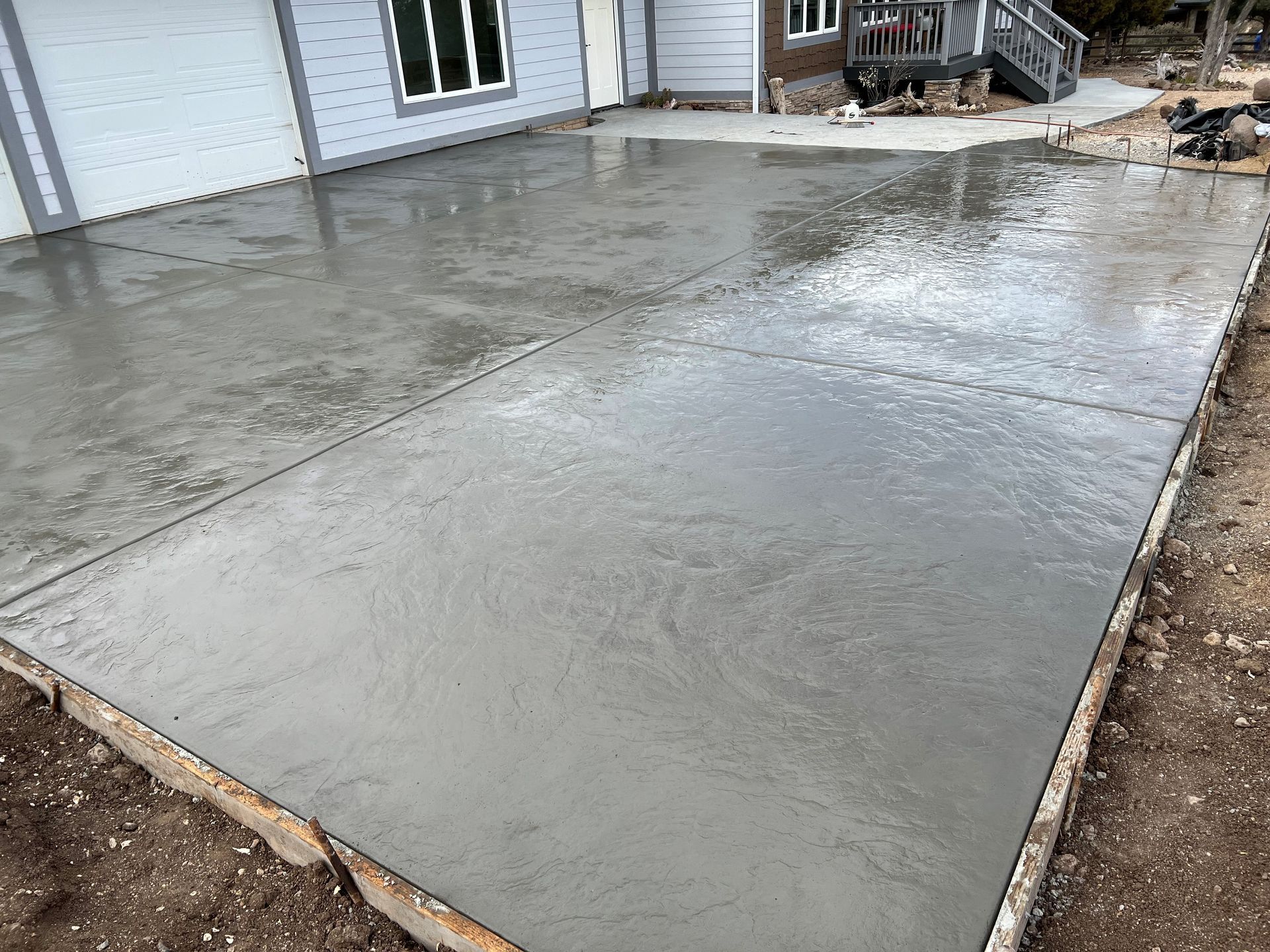 A concrete driveway is being built in front of a house.