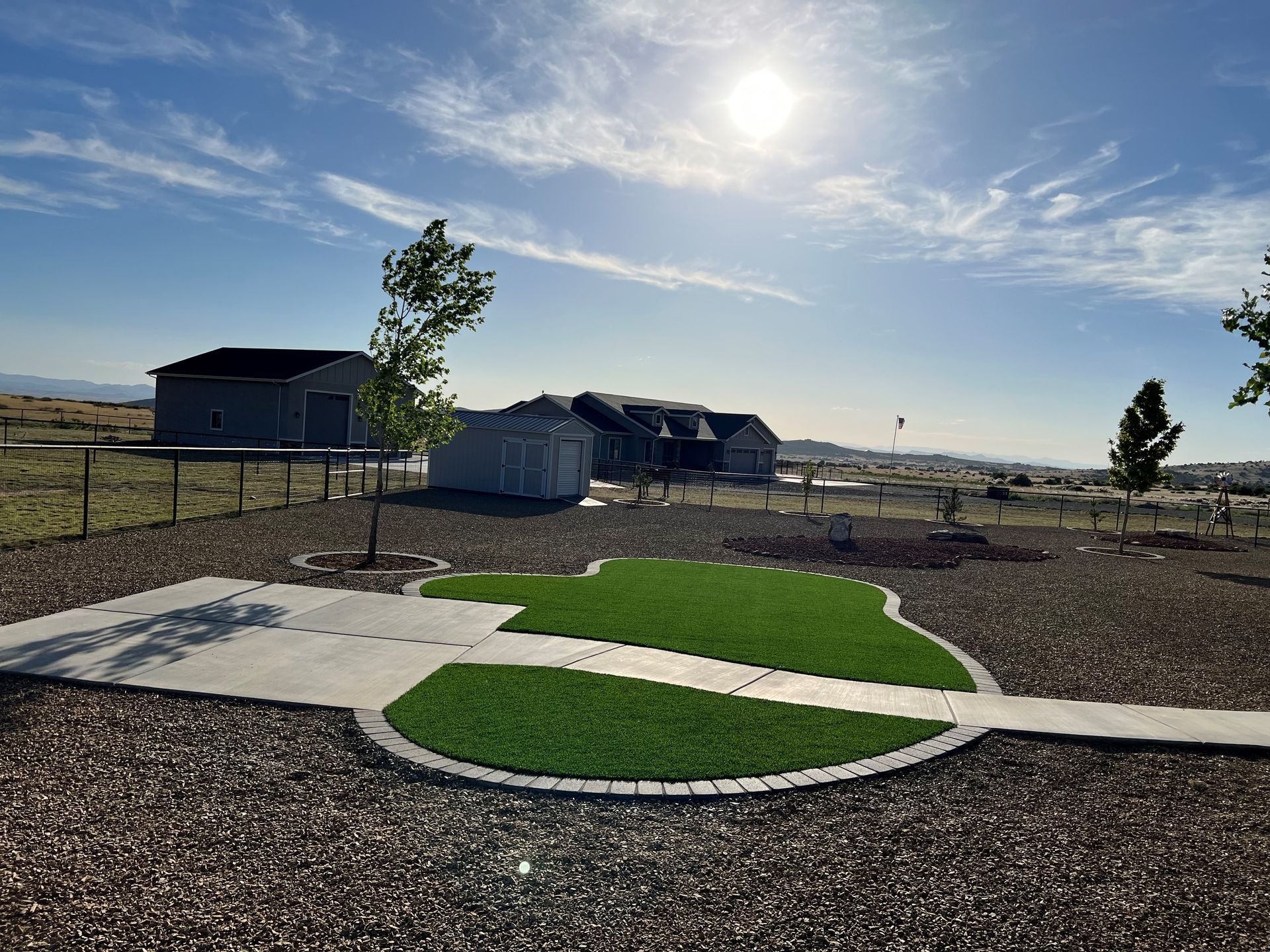 A small house with a red roof and a lush green lawn in front of it.