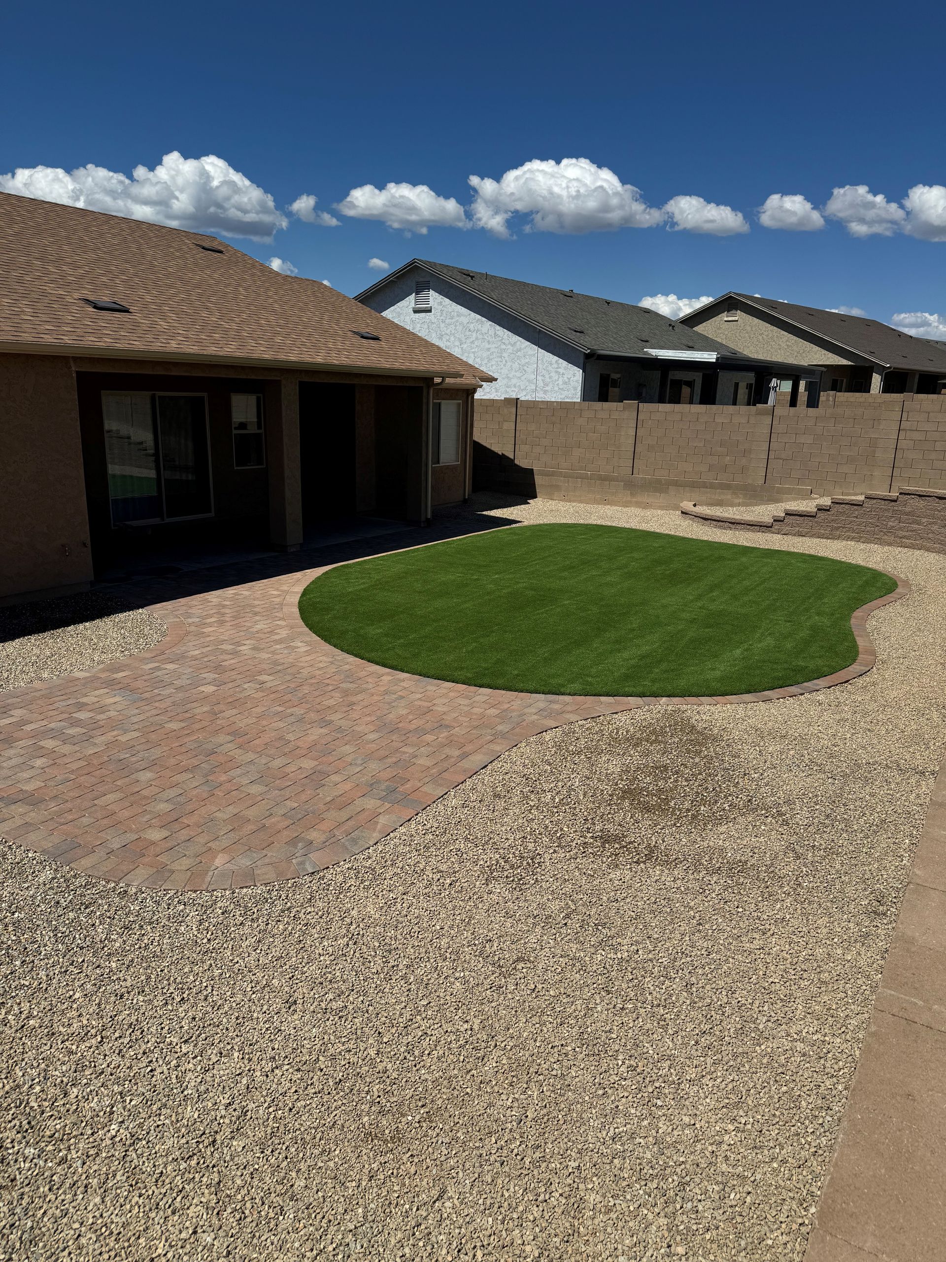 A backyard with a lot of grass and a fence.