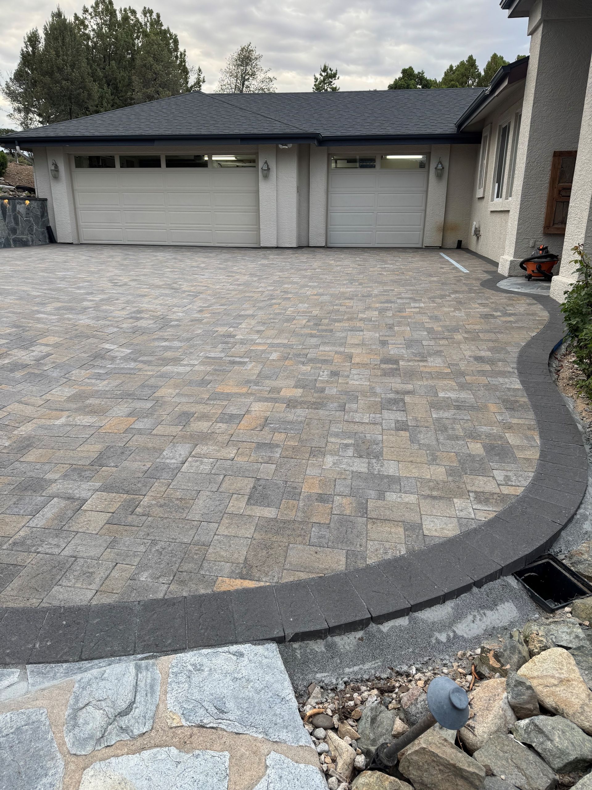 A concrete driveway with stairs leading up to a house with an american flag on the garage door.