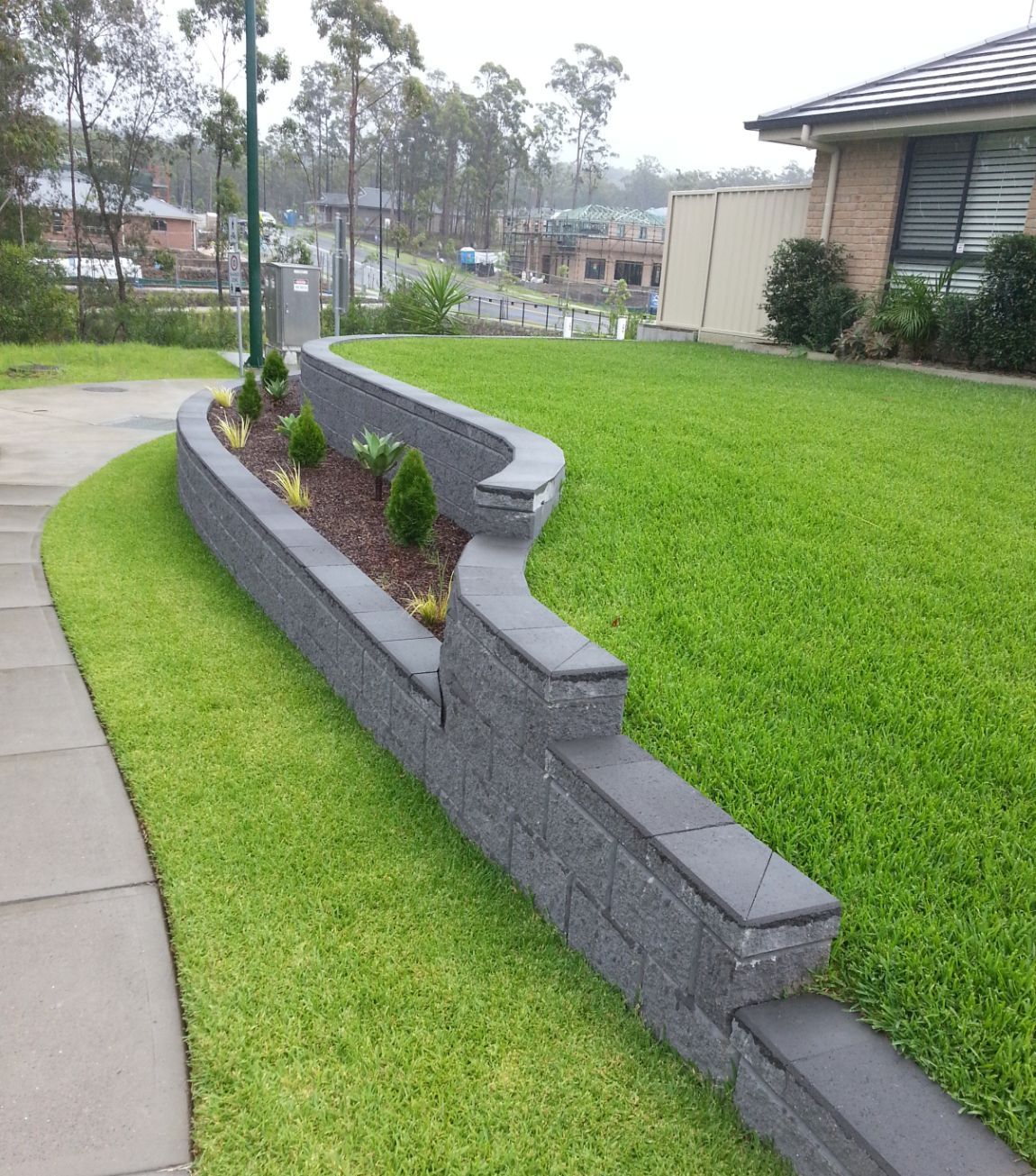 A brick Wall with A Planter in The Middle of It — Creating Eden Landscaping In Speers Point, NSW
