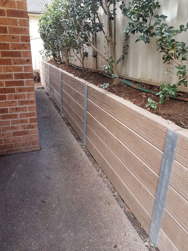 A Brick Wall with Stairs Leading up To a House — Creating Eden Landscaping In Lake Macquarie, NSW