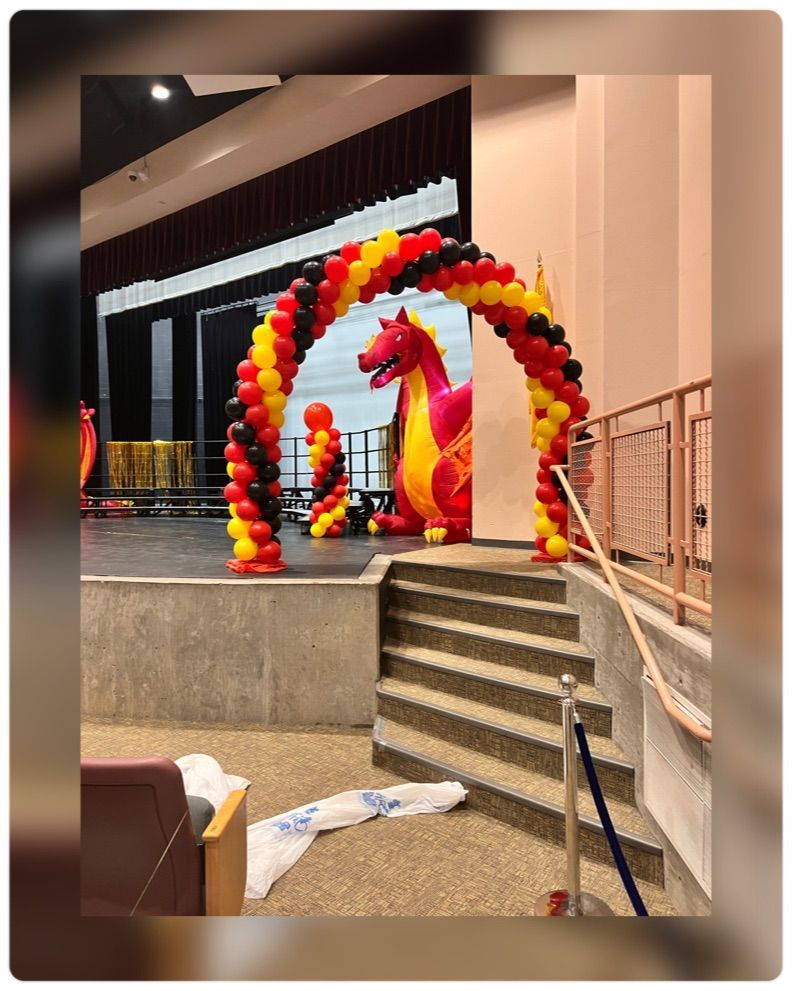 There is a dragon balloon arch in the middle of the room.