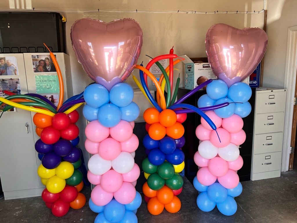 Three columns of balloons with heart shaped balloons on top