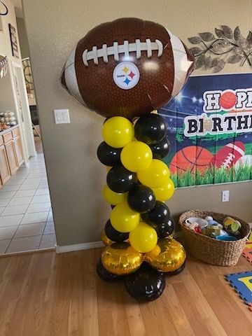 A football balloon is sitting on top of a balloon tower.
