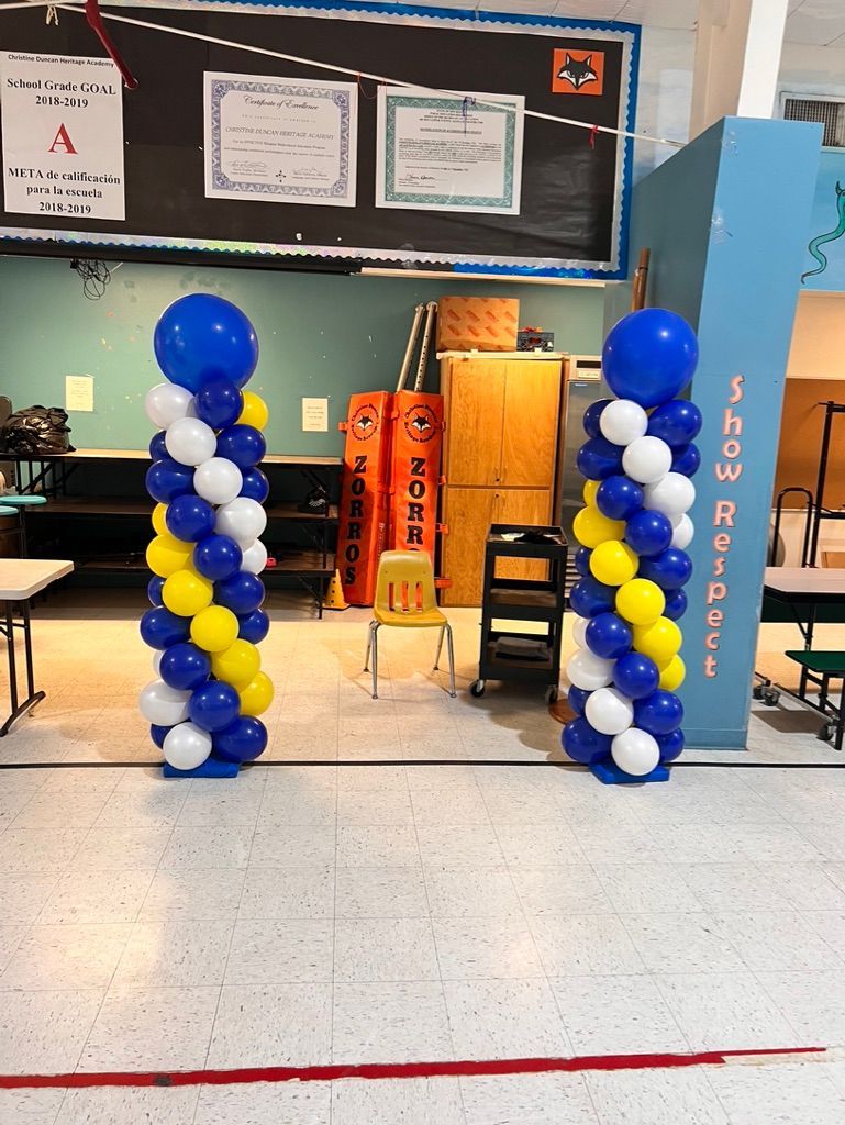 Two columns of blue and yellow balloons in a hallway