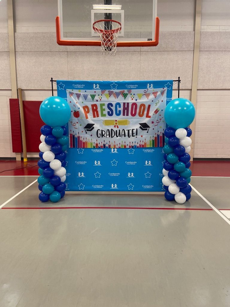 A basketball court with balloons and a sign that says preschool graduate