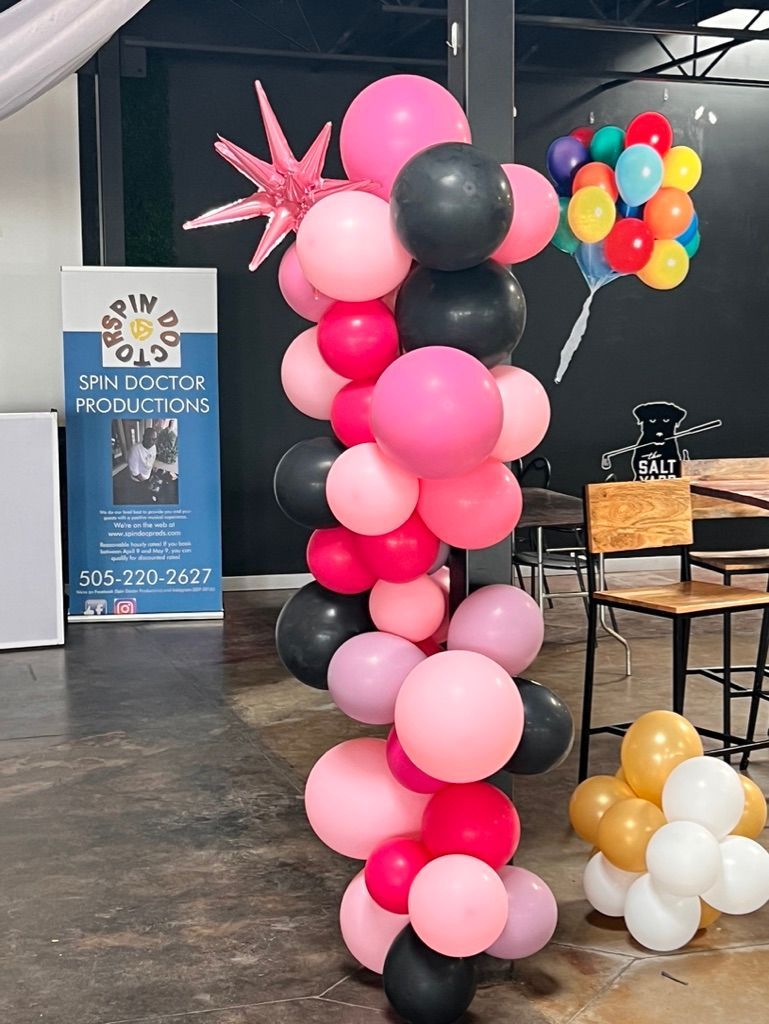 A bunch of balloons are stacked on top of each other in a room.