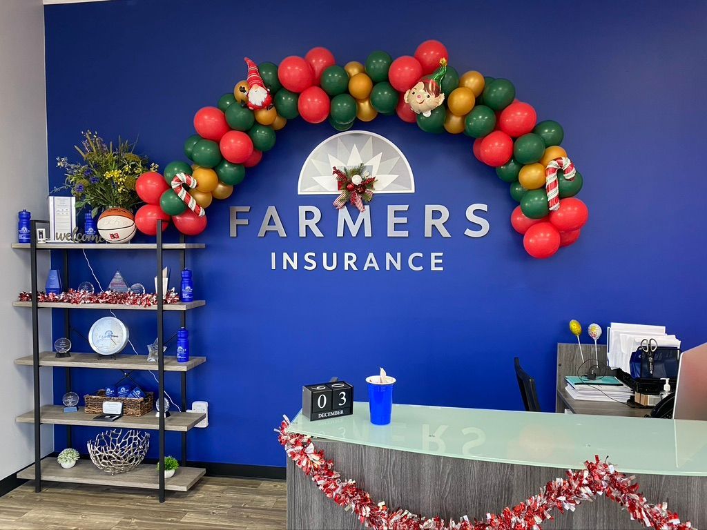 A farmers insurance sign is decorated with balloons for christmas.