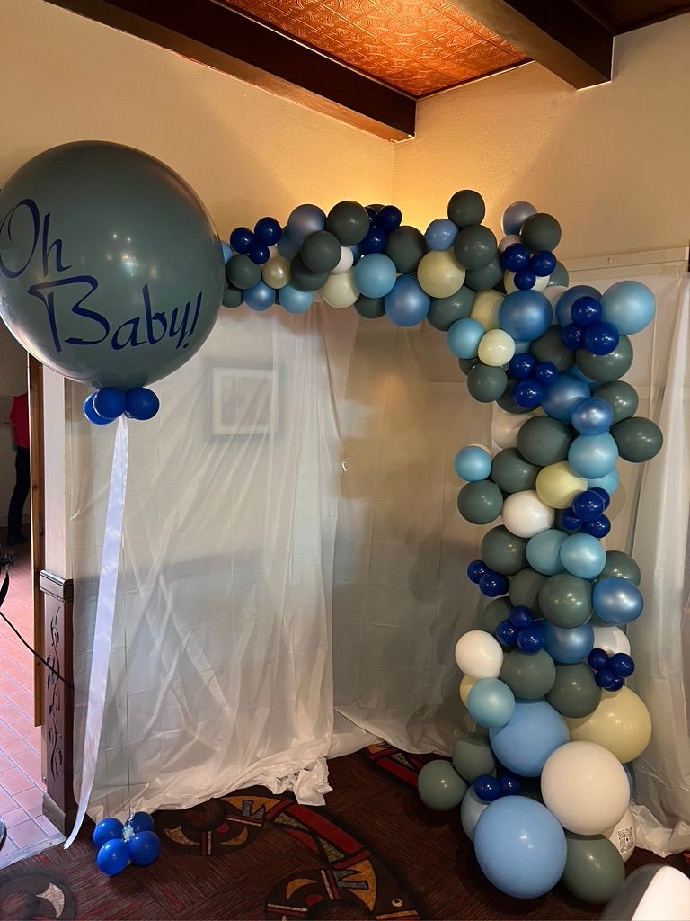 A room filled with balloons and a large balloon that says `` oh baby ''.