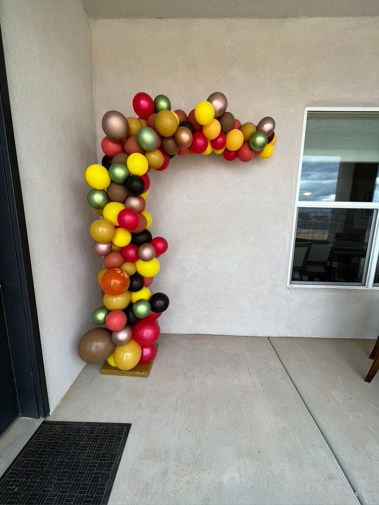 A bunch of colorful balloons are hanging on a wall.