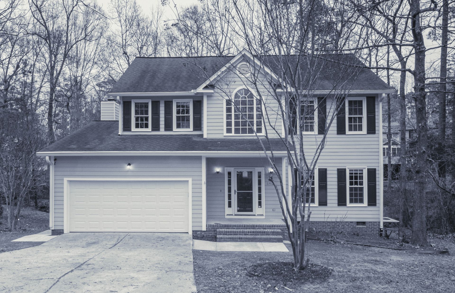 A large house with a white garage door is for sale.