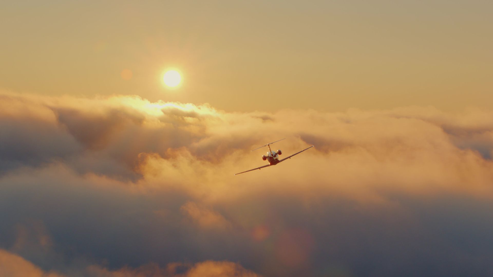 A white and black private jet is on a runway, in front of a hazy green forest.