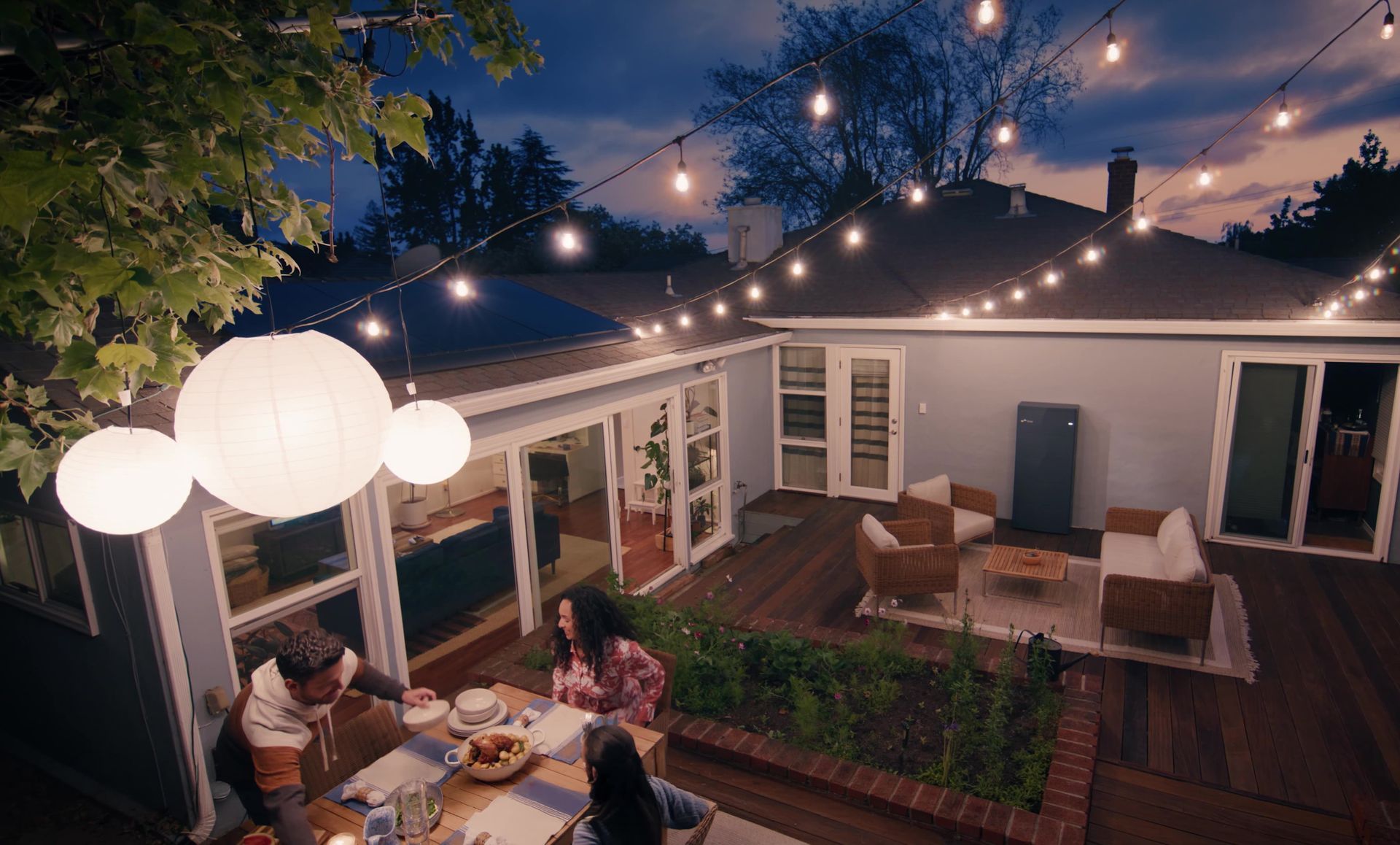 Man in glasses and purple shirt, hands clasped, in a workshop setting with machinery.