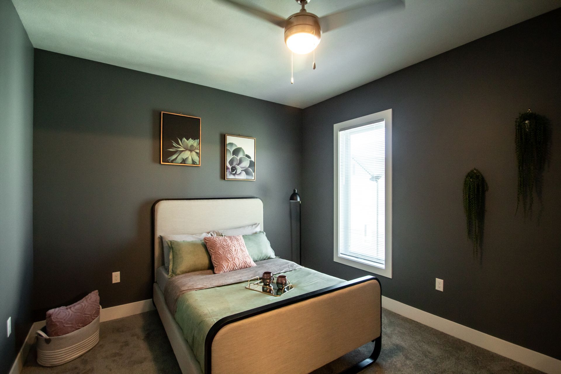 A bedroom with a bed and a ceiling fan.