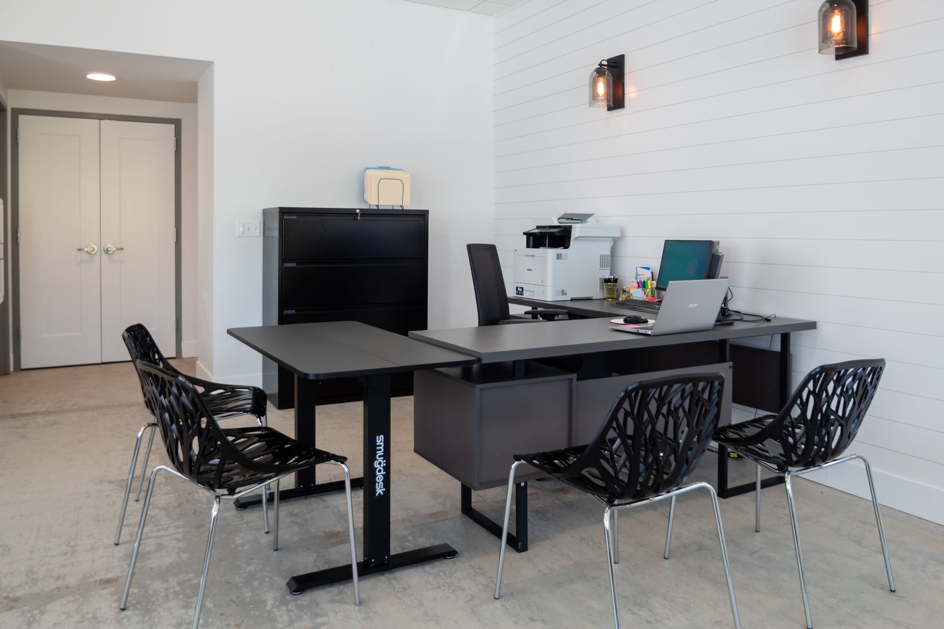 A room with a desk and chairs in it