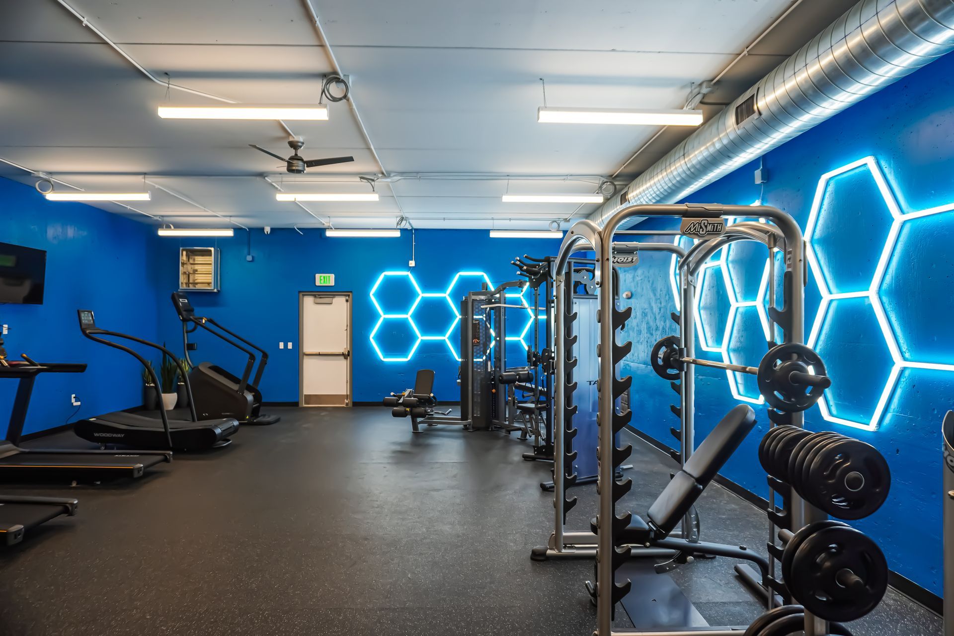A gym with blue walls and a lot of exercise equipment.