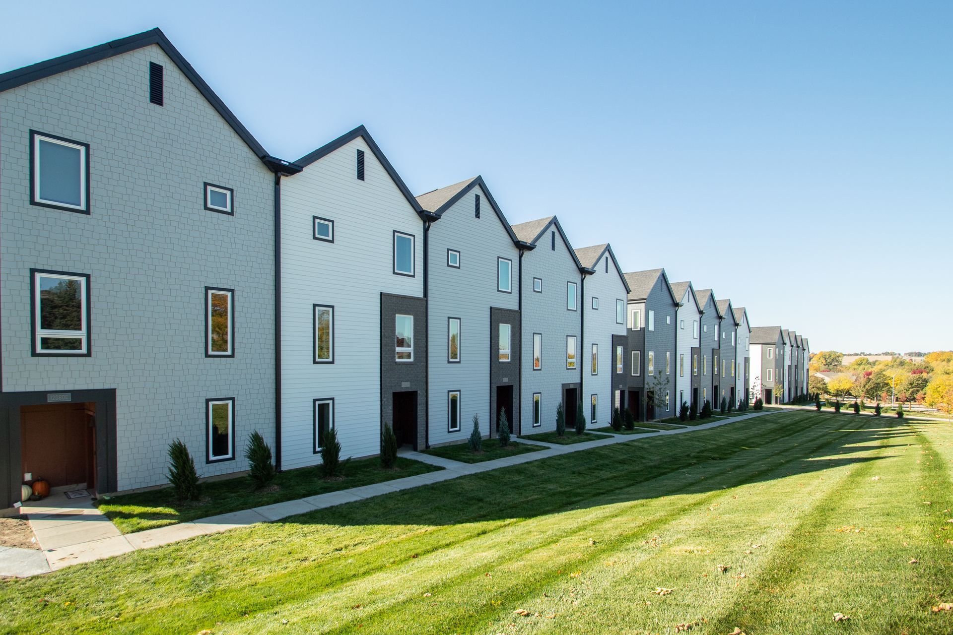 A row of houses with a lush green lawn in front of them.